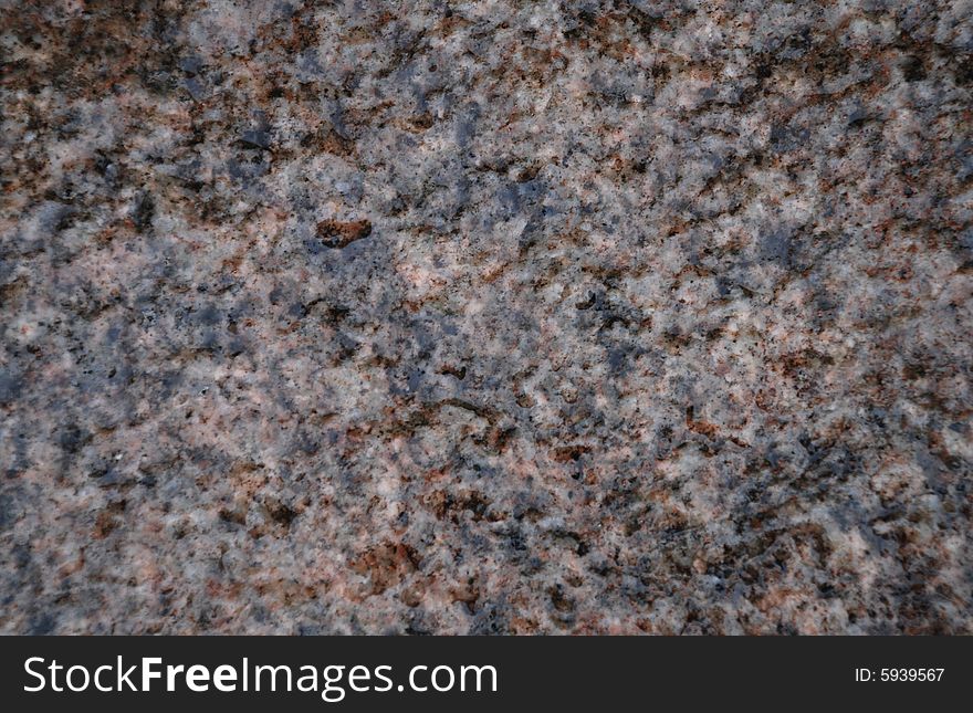 Wet stone texture with grey, black and pink inclusions