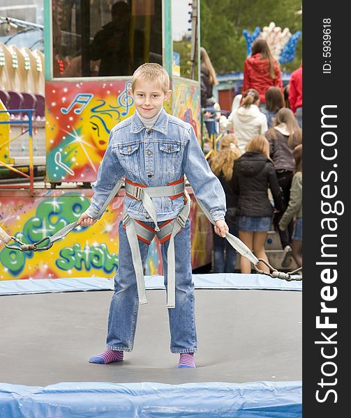 The jumping boy on an attraction in an amusement park