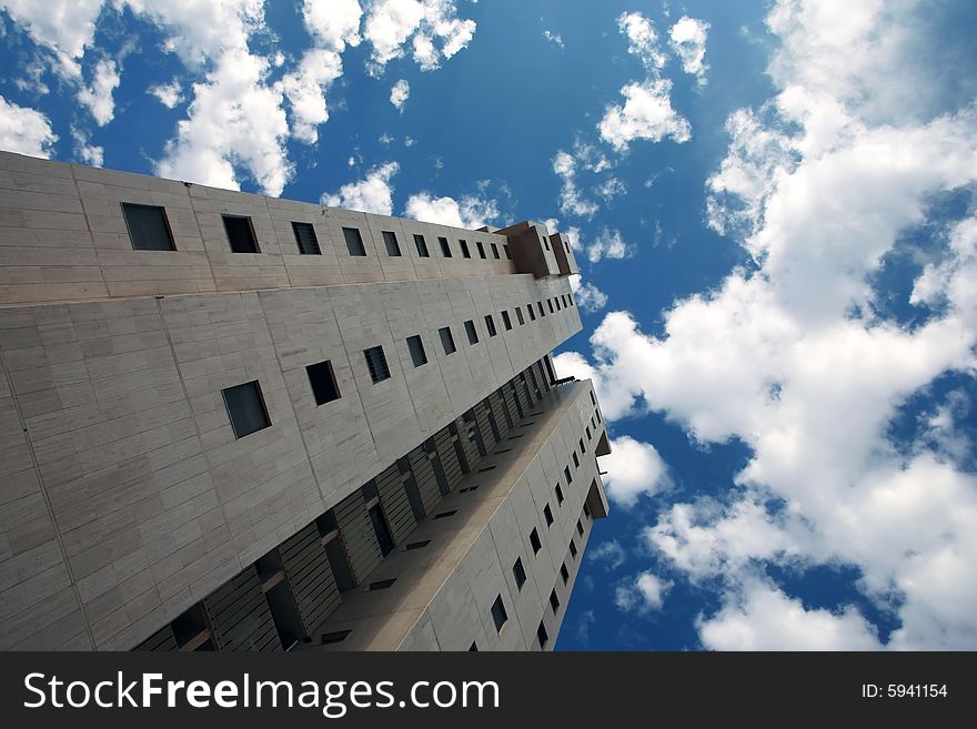 Skyscraper on a blue sky with white clouds