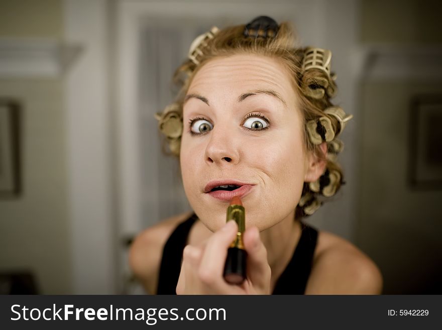 Woman in Curlers Applying Bright Red Lipstick. Woman in Curlers Applying Bright Red Lipstick