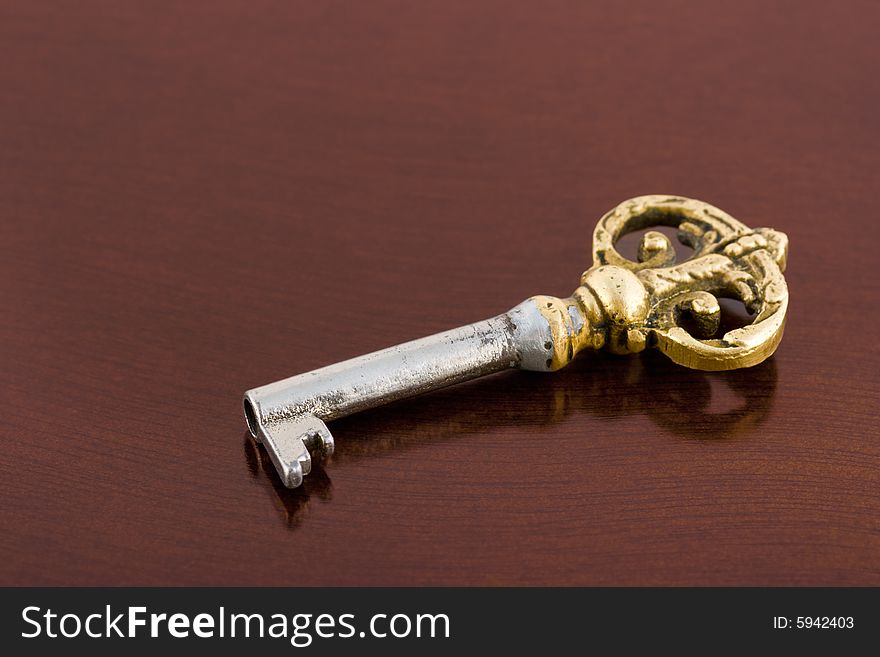 Retro key on wooden table, abstract background
