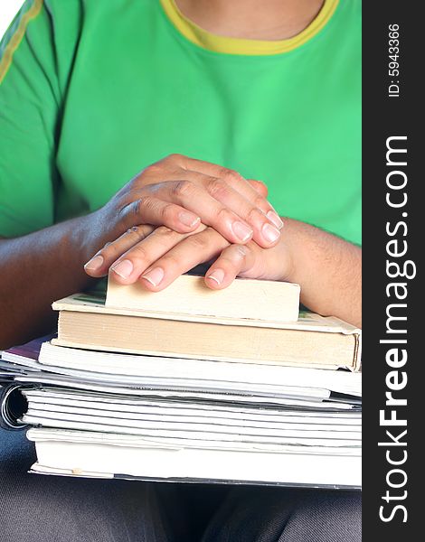 African American college male student with books on his lap and crossed hands. African American college male student with books on his lap and crossed hands