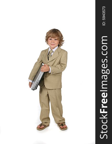 Young boy in tan suit holding laptop under his arm. Young boy in tan suit holding laptop under his arm