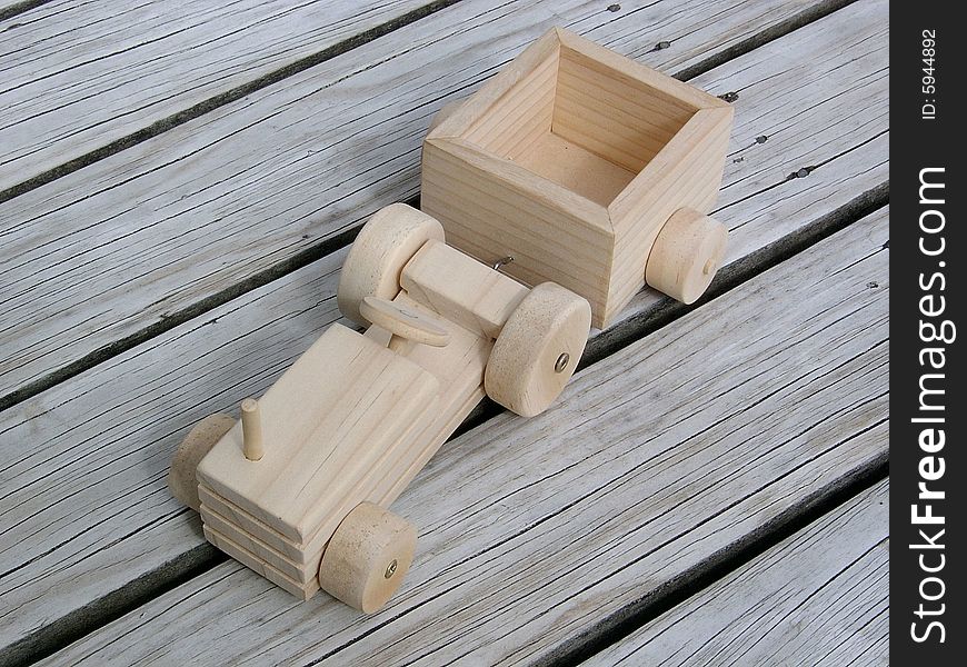 A toy tractor with cart made from wood. A toy tractor with cart made from wood