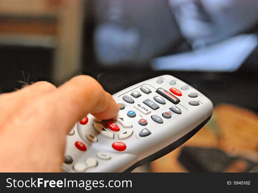 Candid of hand holding remote changing channels. Candid of hand holding remote changing channels