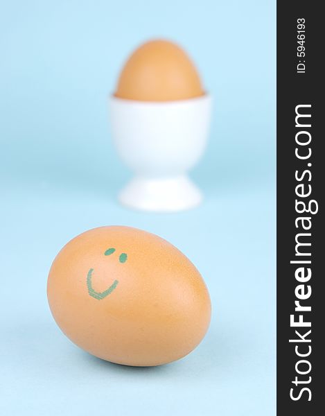 Hard boiled eggs in egg cups isolated against a blue background