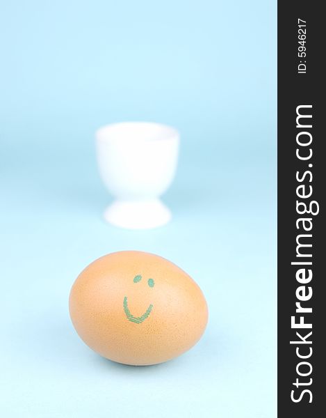 Hard boiled eggs in egg cups isolated against a blue background