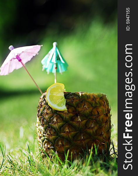 Natural Pineapple hollowed out and filled with an icy drink and tropical umbrellas. Natural Pineapple hollowed out and filled with an icy drink and tropical umbrellas