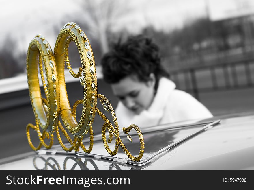 Wedding car decoration rings, gray-scale and gold, bride on background plan