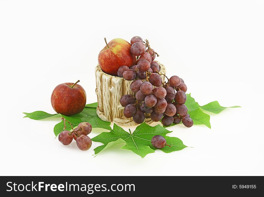 Composition from red apples and berries of grapes in a ceramic vase. Composition from red apples and berries of grapes in a ceramic vase