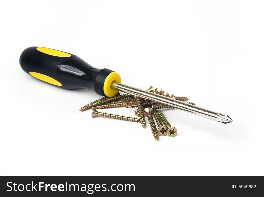Yellow and black handled phillips screwdriver with pile of screws on white background. Yellow and black handled phillips screwdriver with pile of screws on white background