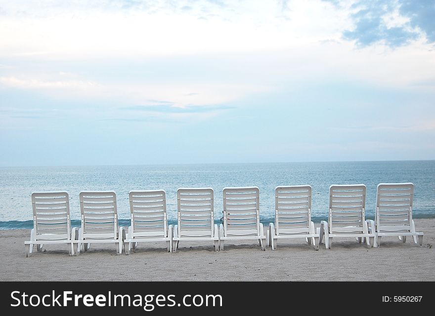 Row of chairs at a bech facing the ocean. Row of chairs at a bech facing the ocean