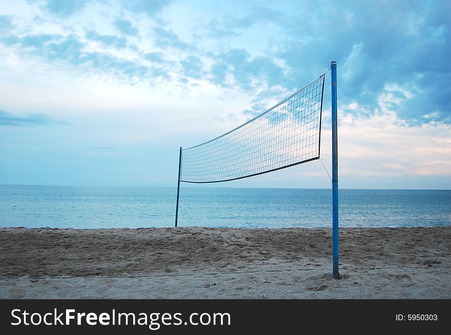 Volleyball net at a lonely beach with blue sky in the background