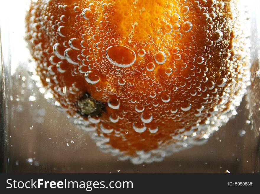 Tangerine in water with bubbles in a glass vase. Tangerine in water with bubbles in a glass vase
