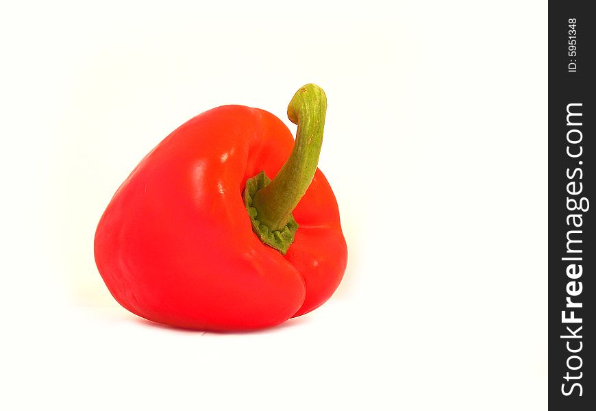 A red sweet pepper on a white background. Shot taken from 2/3 perspective