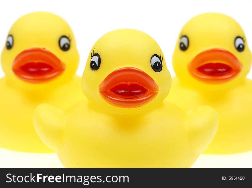 Small yellow plastic ducks isolated on a white background