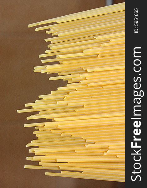 Raw spaghetti with dark background, pointing left