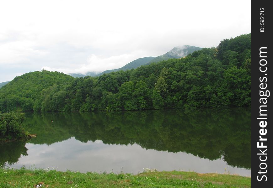 Lake Ruzin in Slovakia in the afternoon after the rain, forest is reflecting in the lake