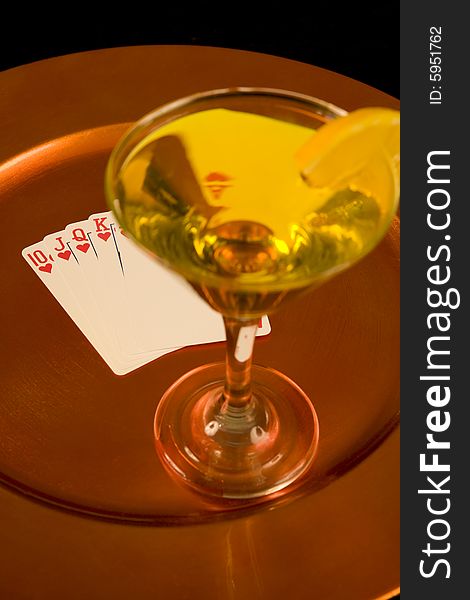 Yellow cocktail and royal flush on tray
