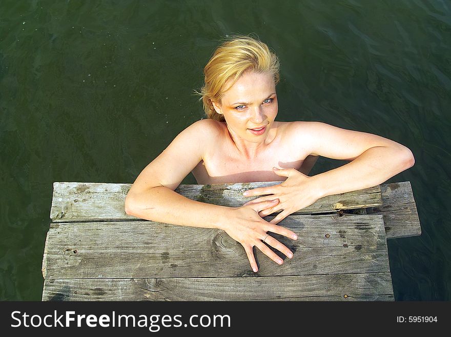 Nice girl in country pond in summer