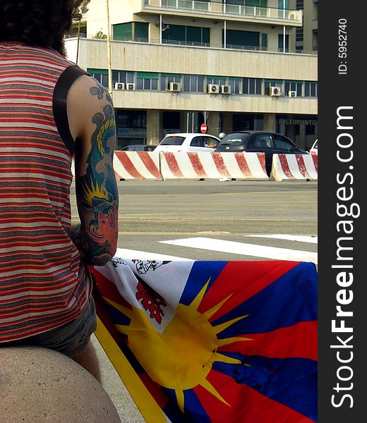 A man on the street with a flag of tibet. A man on the street with a flag of tibet