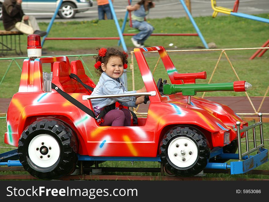 Glad child rides on round-robins on colorful baby car.