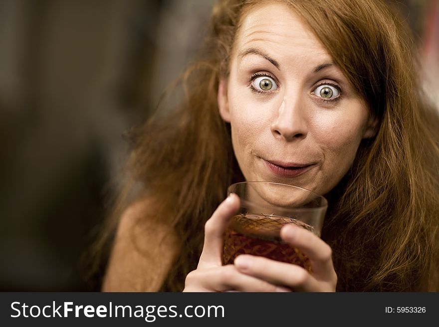 Woman with big eyes and hair sipping cocktail. Woman with big eyes and hair sipping cocktail