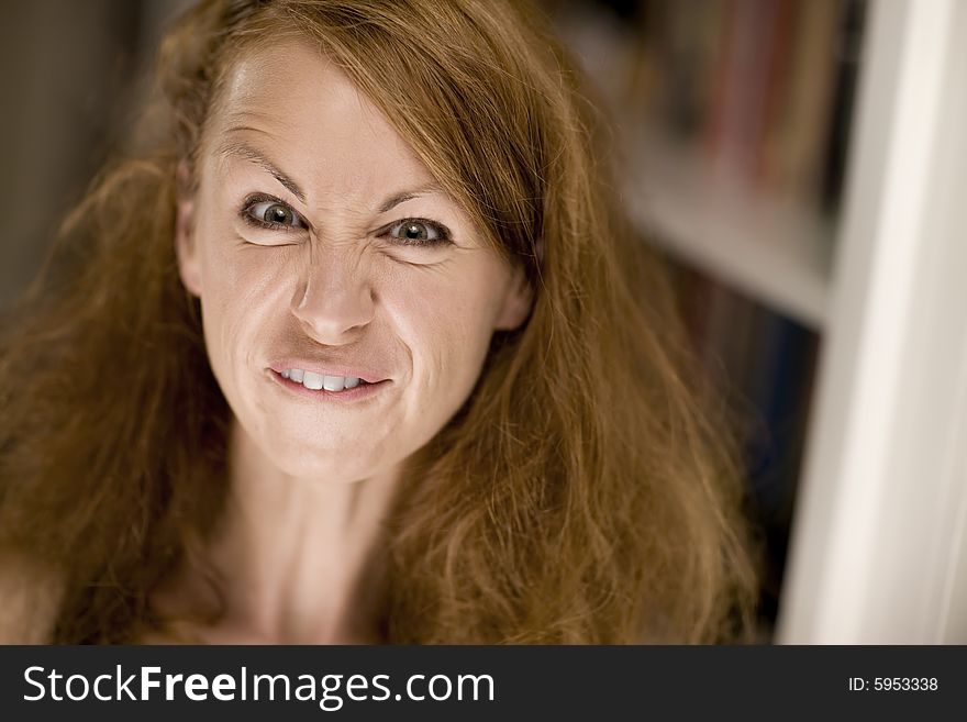 Woman with big hair scrunching her face to make a funny expression. Woman with big hair scrunching her face to make a funny expression