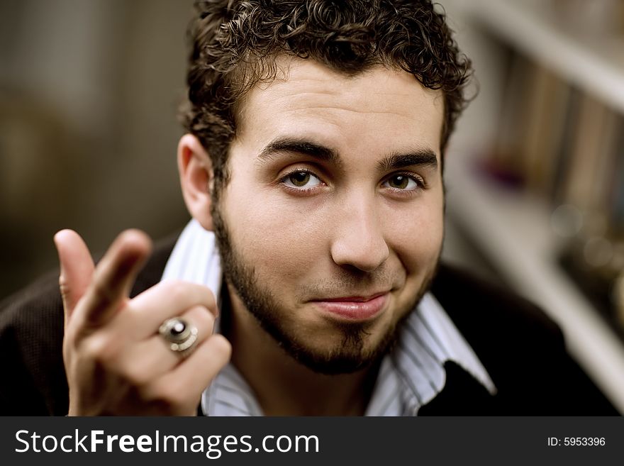 Portrait of handsome young man with beard gesturing with his hand