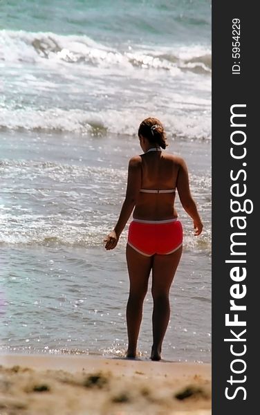 Young woman at beach, looking out at the waves. East coast, USA. Film scan. Young woman at beach, looking out at the waves. East coast, USA. Film scan.