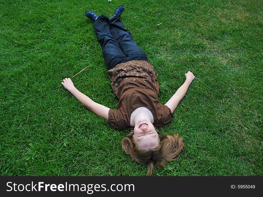 Young girl laying on grass with eyes closed