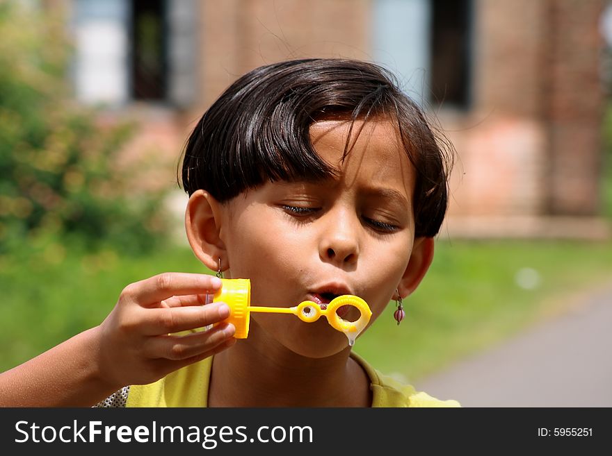 A girl trying hard to blow the soap bubble. A girl trying hard to blow the soap bubble.