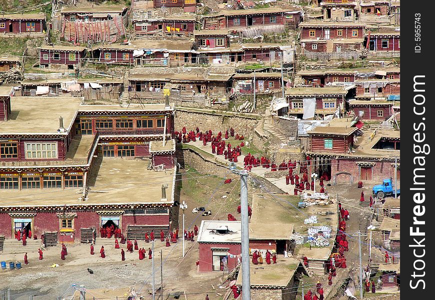 A view of the buddhism college in west of China.Lamas in red were lining up for a ceremony of praying for the dead. The Buddhism college is a secret and saintly place which buddhist attending in a advanced studies.Also it is amazing to see so many house built around the mountain. A view of the buddhism college in west of China.Lamas in red were lining up for a ceremony of praying for the dead. The Buddhism college is a secret and saintly place which buddhist attending in a advanced studies.Also it is amazing to see so many house built around the mountain.