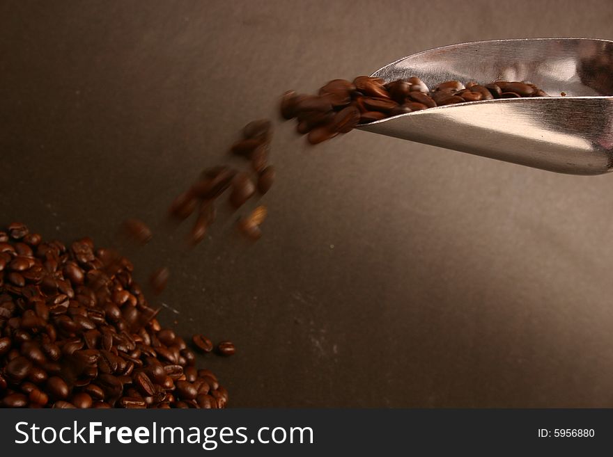 A scoop of falling coffee beans. A scoop of falling coffee beans