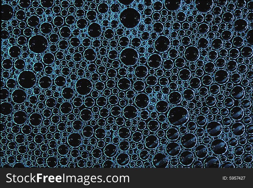 Layer of blue soap bubbles with black background. Layer of blue soap bubbles with black background