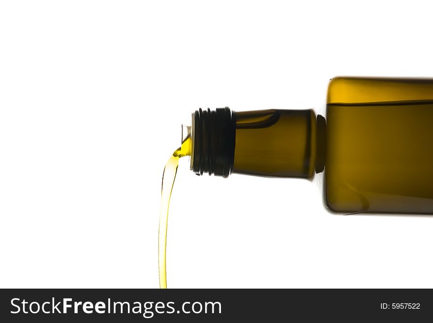 Olive oil being poured from a bottle isolated on white