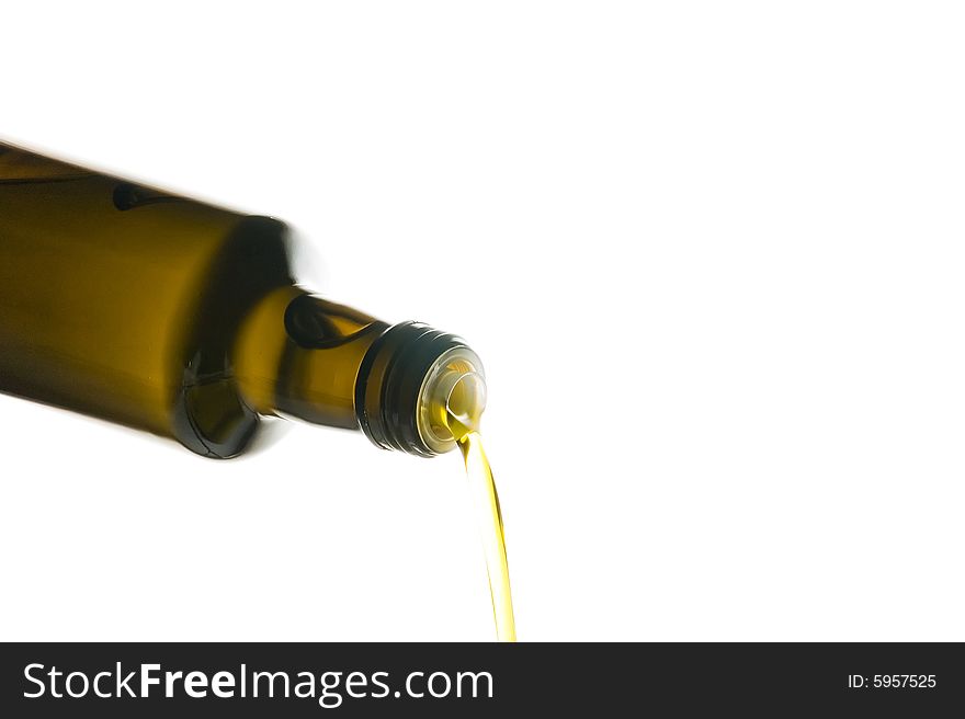 Olive oil being poured from a bottle isolated on white