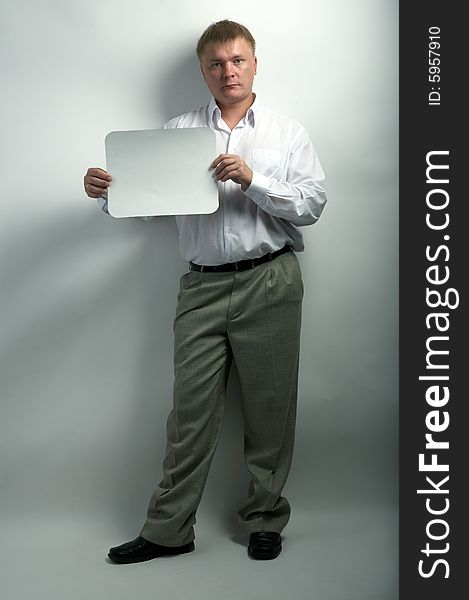 Serious businessman hold white frame on gray background