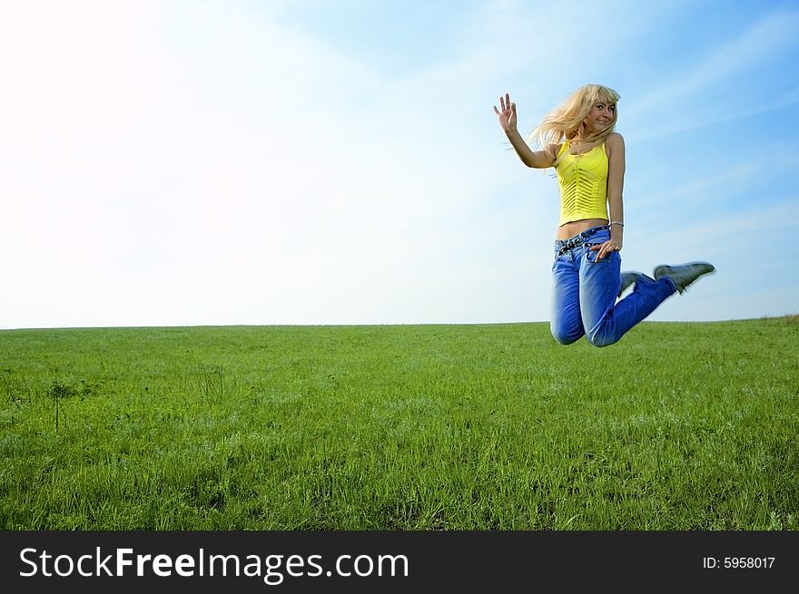 Happy beauty young woman jump in field with green grass