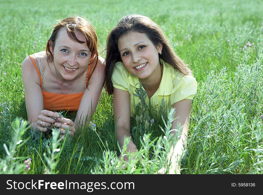 Two beautiful girls  on green grass