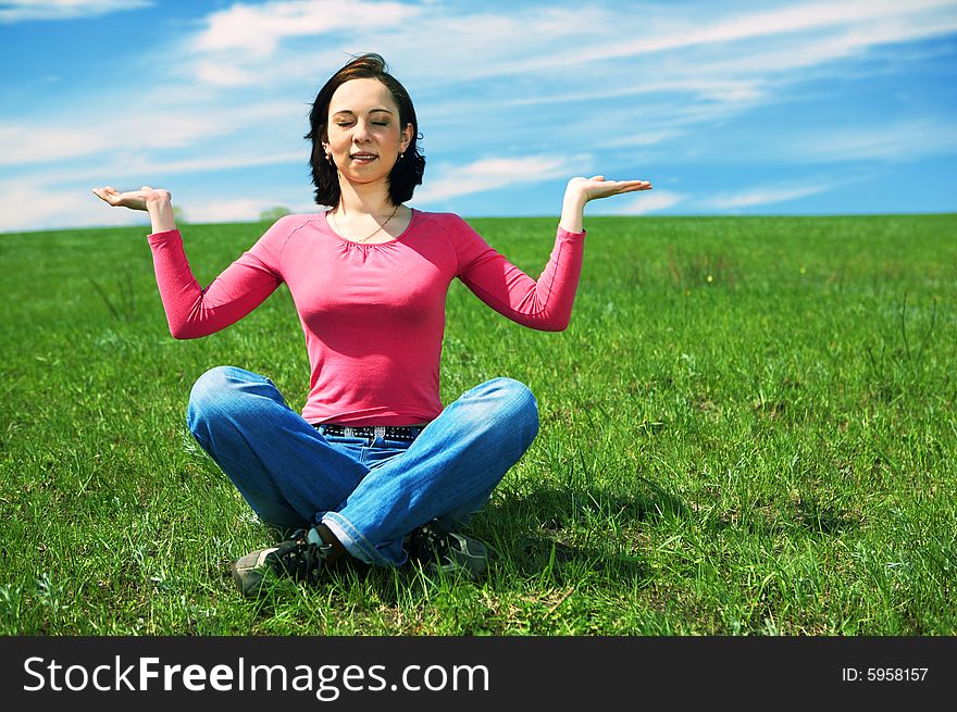 Woman in field hold hand palm up under blue sky and clouds