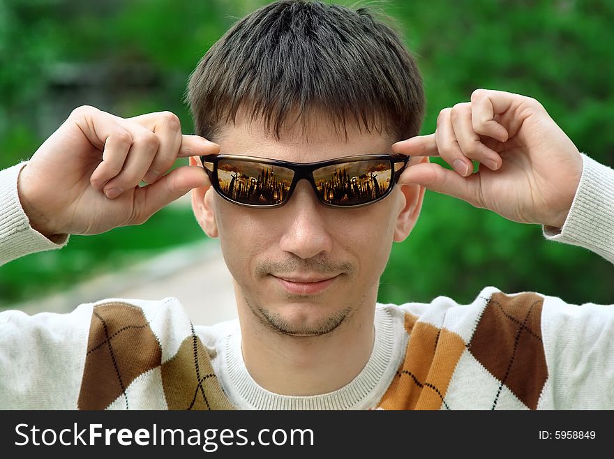 Portrait of the man in a sweater and in glasses