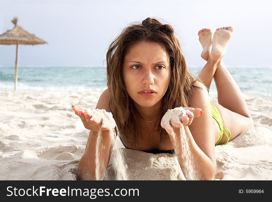 Beautiful young woman is lying on the beach;sea and sky on background. Beautiful young woman is lying on the beach;sea and sky on background