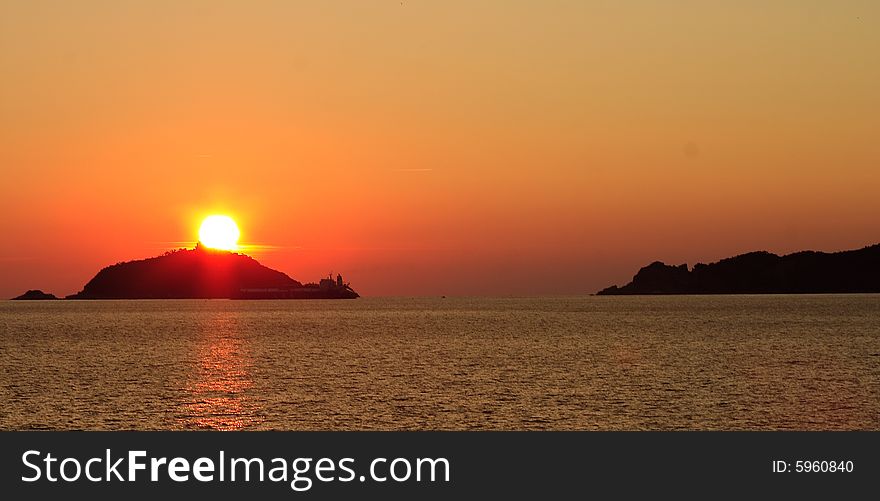 Sunrise over the sea through low clouds