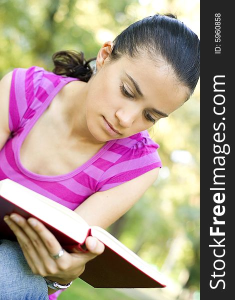 Young woman reading book outdoor. Young woman reading book outdoor