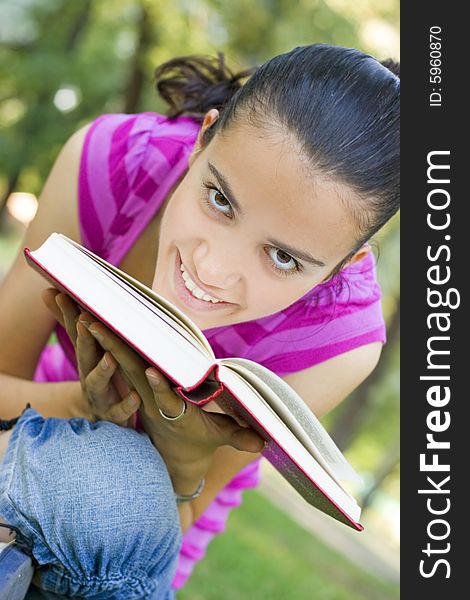 Young woman reading book outdoor. Young woman reading book outdoor