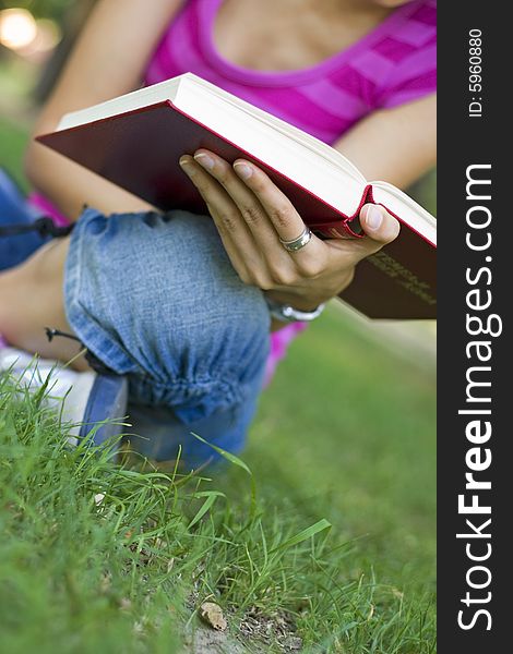 Young woman reading book outdoor. Young woman reading book outdoor