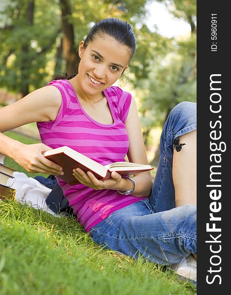 Young woman reading book outdoor. Young woman reading book outdoor