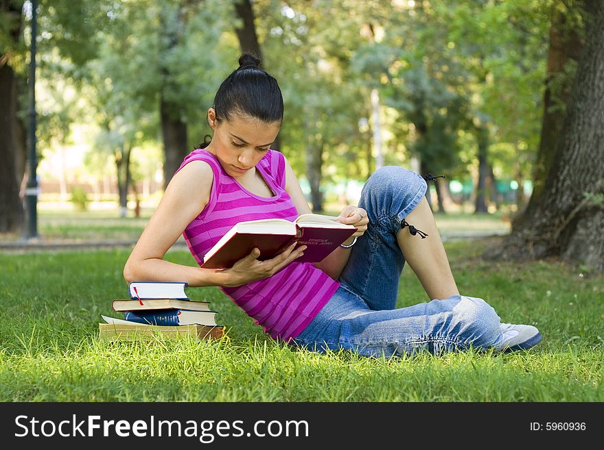 Young woman reading book outdoor. Young woman reading book outdoor