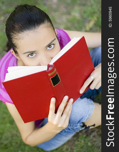 Young woman reading book outdoor. Young woman reading book outdoor